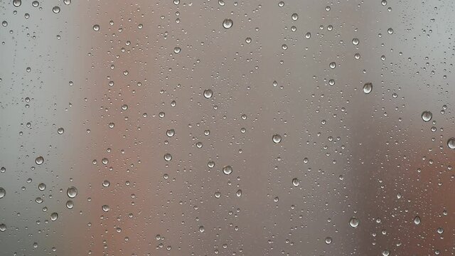 Macro photography of raindrops streaming down on the window. Rain outside the window