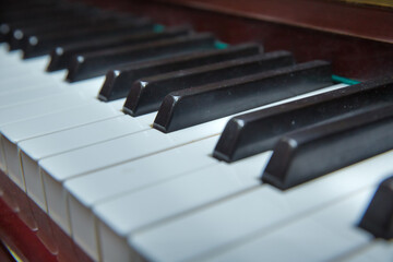 Fototapeta na wymiar piano presses . Piano keys close up. Musical instrument . Select focus and soft focus.Close-up of a wooden piano . Defocused classic piano keyboard in white and brown colors .