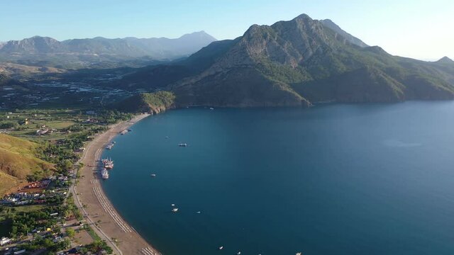 Long beach coast, dark teal sea and bay in Adrasan village Mediterranean coast, great place for holiday. Aerial view with drone. Antalya, TURKEY