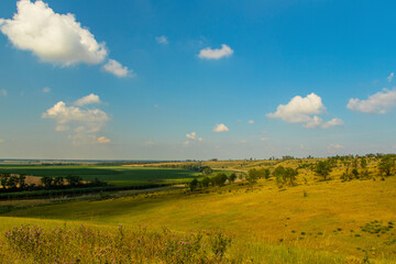 Obraz premium Beautiful view from the hill on the blue sky, the river and agricultural fields extending beyond the horizon.