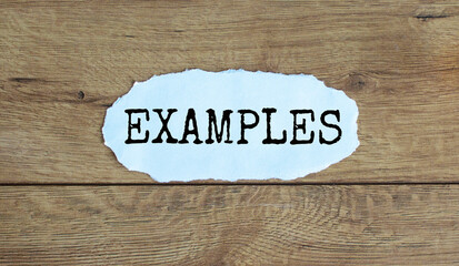 Text 'examples' on the piece of paper. Beautiful wooden background. Business concept.