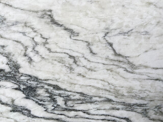 Polished marble stone piece with white and gray waves like lines
