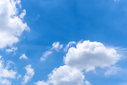 White clouds on bright blue sky in sunny day.