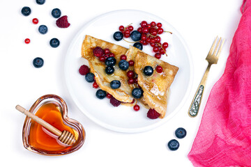 Homemade crepes with honey and barriers plat-lay breakfast image. Natural breakfast concept.