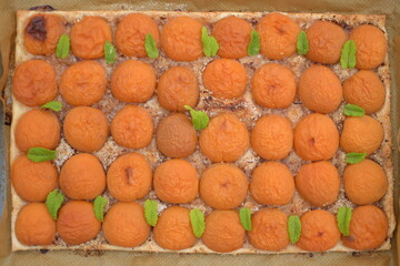 Ein Aprikosen Kuchen auf Blätterteig mit frische grüne Minze Blätter auf einem Blech. Das ganze...