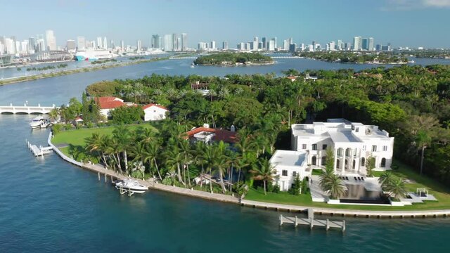 4K aerial close view on Star Island with Miami downtown on a background. Lavish nature of green tropical island. Stock video for tourism business. Exclusive real estate, expensive homes, Florida, USA