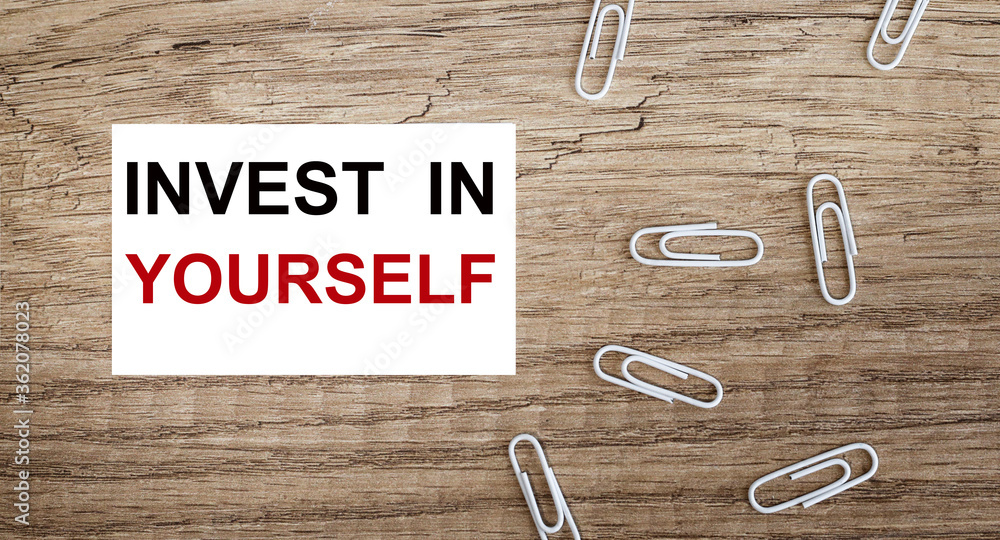 Poster invest in yourself text written in a notebook. view from above
