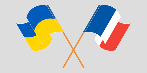 Crossed and waving flags of Ukraine and France
