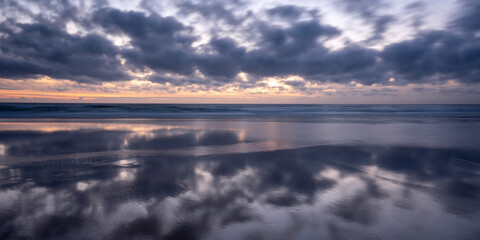 Fototapeta premium gwithian beach at sunset near godfrey and hayle cornwall uk at sunset with reflections in the sand