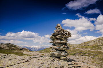 stones piled like a pyramid on a rock. Stones in the mountains against the blue sky. Stone structure