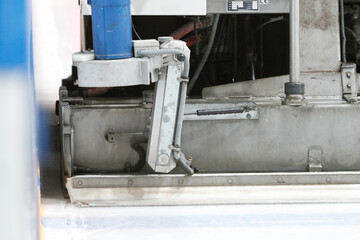 Closeup of ice maintenance vehicle making new ice surface during a game break.