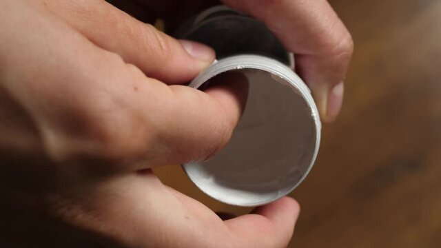 picking up white cream anti-chafing cream on  finger