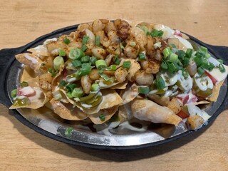 Spicy shrimp and scallop nachos with queso cheese sauce, jalapeños, scallions, and tomatoes 