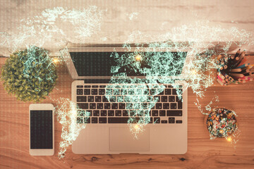Social network hologram drawings over computer on the desktop background. Top view. Multi exposure. Concept of people connection.