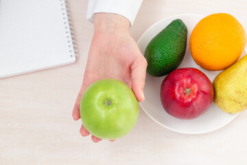 Close up of hand nutritionist holding green apple