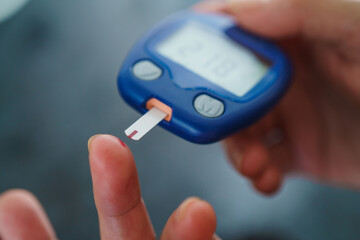 Medicine, Diabetes, Glycemia, Health care and people concept - close up of female using lancelet on...