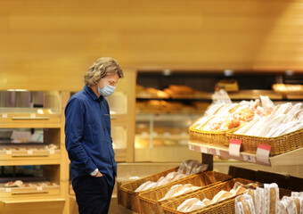 Supermarket shopping, face mask and gloves,Young man shopping in supermarket, reading product information