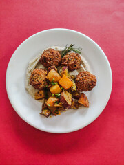 Falafel vegan dish with vegetables in red background 