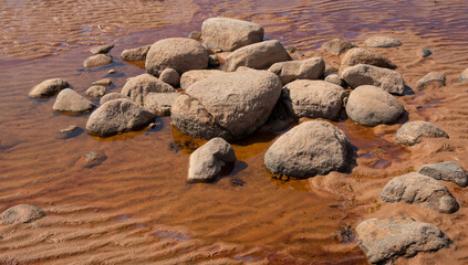 Nice landscape with boulders of different sizes by the sea on a sunny day. Latvia. The rocky coast of Vidzeme