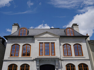 Newly built house with round topped brown casement windows