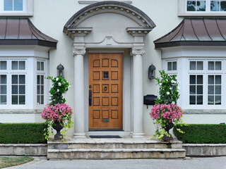 Fototapeta na wymiar elegant wooden front door of stucco house with portico entrance