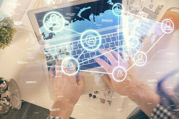 Double exposure of man's hands typing over computer keyboard and social network theme hologram drawing. Top view. People connection web concept.