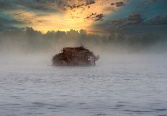 Hunters Duck blind in the foggy lake at sunrise