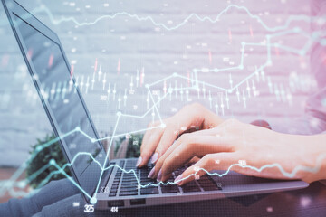 Multi exposure of woman hands typing on computer and forex chart hologram drawing. Stock market analysis concept.