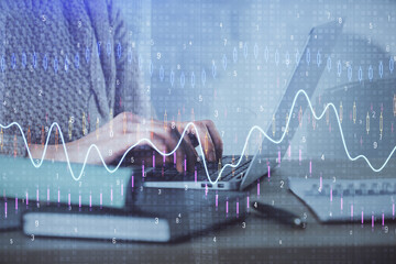 Double exposure of woman hands typing on computer and forex chart hologram drawing. Stock market...