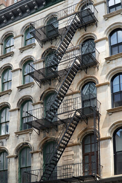 Facade of old New York apartment building with exterior fire escape ladders