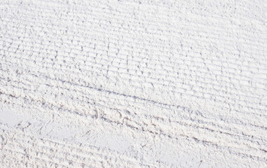 White sand on the beach with wheel pattern texture. Bicycle tire marks on sand. Tropical beach photo background