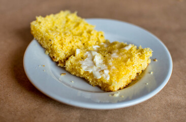 Savory golden Cornbread sliced open and spread  with butter