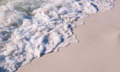 Sea beach with foamy wave photo background. Coral beach sand with sea tide. White sand of oceanic coastline