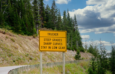 A important sign warns truckers with big rigs about Steep grade mountain driving ahead