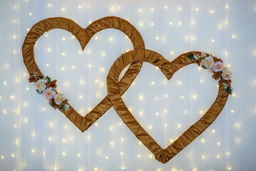 Beautiful golden brown and white decoration for wedding ceremony or banquet decoration. Wall ornament with two big hearts and led lights