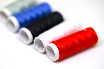 Thread spool set on white background. Basic color of threads: red, white, black. Simple thread...