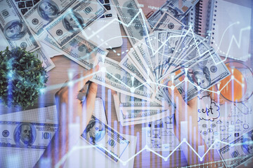 Multi exposure of financial graph drawing hologram and USA dollars bills and man hands. Analysis concept.