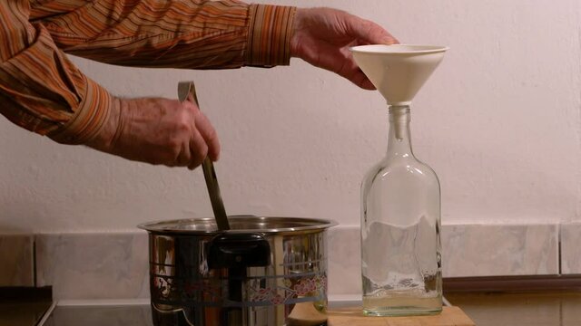 Pouring Elder Flower Juice into sterile bottle (Sambucus nigra)