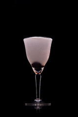 Aviation Cocktail in a nick and nora glass with a black background