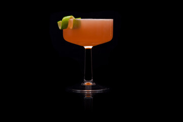 Pegu Club Cocktail with lime peel garnish on a black background