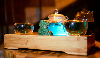 Chinese traditional tea tray with dragon in the foreground, hookah tube and kettle cups