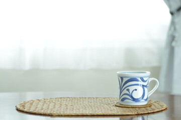 picture mug. This is a very fine example of Japanese traditional  ceramic &ldquo; tobe ware &rdquo;.  This expensive antique walnut table is made in England.  blurred background with copy space.
