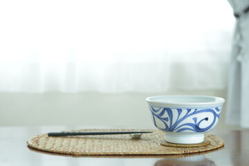 picture bowl. This is a very fine example of Japanese traditional  ceramic &ldquo; tobe ware &rdquo;.  This expensive antique walnut table is made in England.  blurred background with copy space.