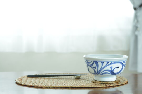 picture bowl. This is a very fine example of Japanese traditional  ceramic &ldquo; tobe ware &rdquo;.  This expensive antique walnut table is made in England.  blurred background with copy space.
