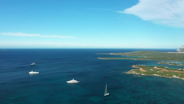 View from above, stunning aerial view of some yachts and sailboat sailing on a beautiful turquoise sea. Porto Cervo, Sardinia, Italy.