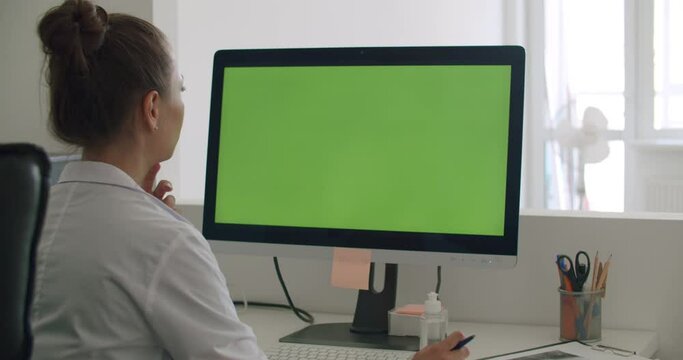 Doctor work on computer with green mock-up screen