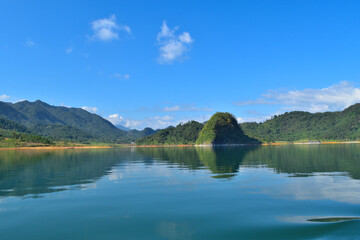 a beautiful lake surrounded by  the mountains in the Summer with white cloud in the blue sky