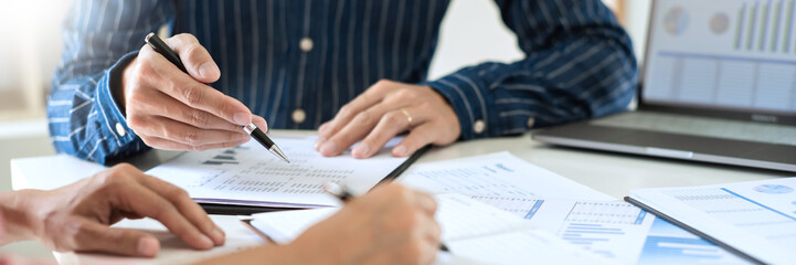 Business team working with plan on office desk with new startup project analysing financial document data
