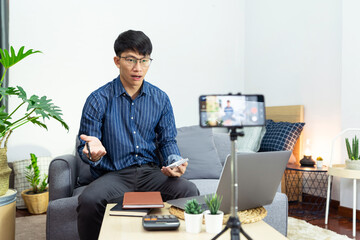 Asian blogger recording vlog video on camera review of product at home office