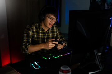 Asian man cyber sport gamer concentrated playing video games on computer eSport concept - obrazy, fototapety, plakaty
